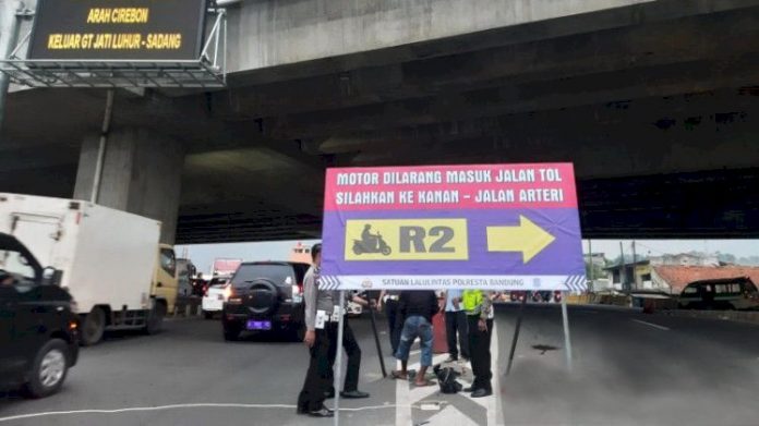 Satuan Lalu Lintas (Satlantas) Polresta Bandung memperbesar rambu petunjuk bagi pemudik sepeda motor agar tidak masuk nyelonong ke lajur yang menuju Gerbang Tol (GT) Cileunyi, Sabtu, 7/5/2022. (antara)